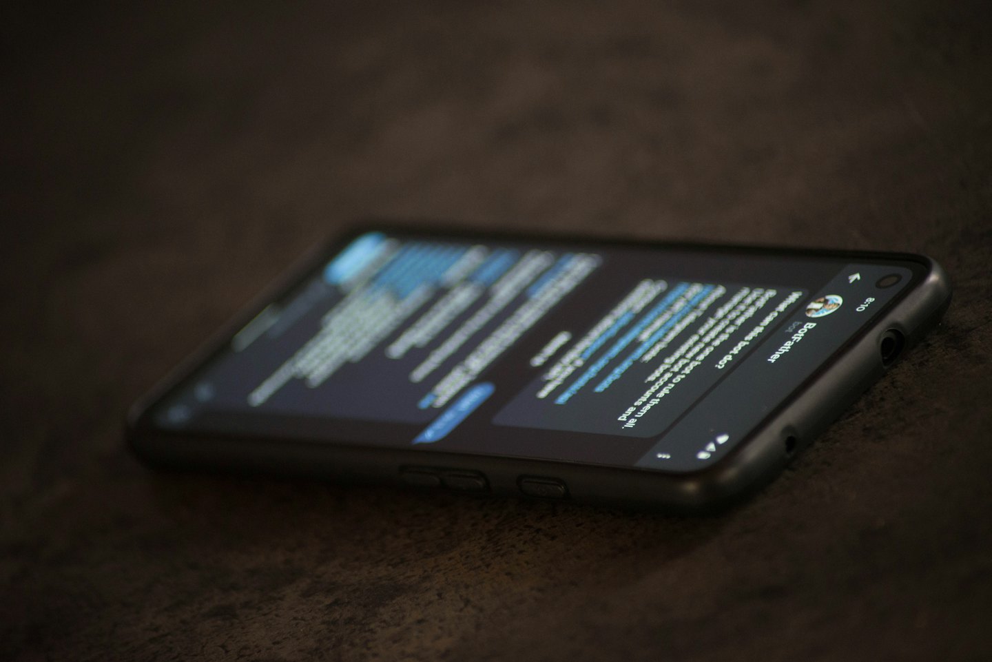 Smartphone mit einer Textnachricht auf dunklem Holz.